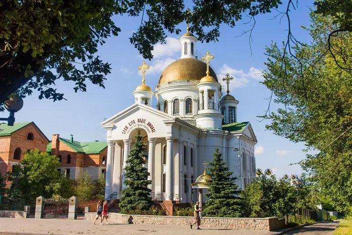 Логотип ПЦУ на фоні парафіїв Московської церкви